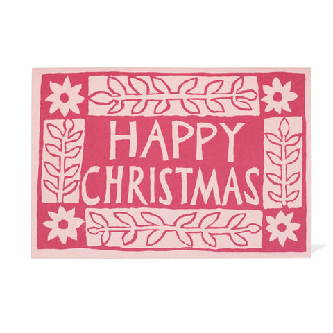 Light pink and magenta card with flower designs in blocks with the words "Happy Christmas" on it. 