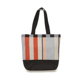 A tote with a black bottom and black straps with a multicoloured face. 