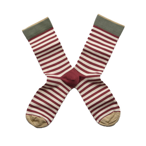 A pair of burgundy striped socks with a block colour of green at the top and ochre on the toes. 