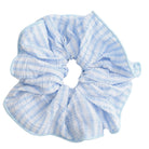 White and blue striped hair scrunchie against a white background.