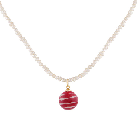 A red and ivory striped glass ball pendant hangs from a pearl strand necklace. 