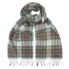 A styled scarf in green and beige tartan pattern with tassels. 