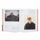 Open book showing a page with a photo of a person in a black salon cape and text on a white background.