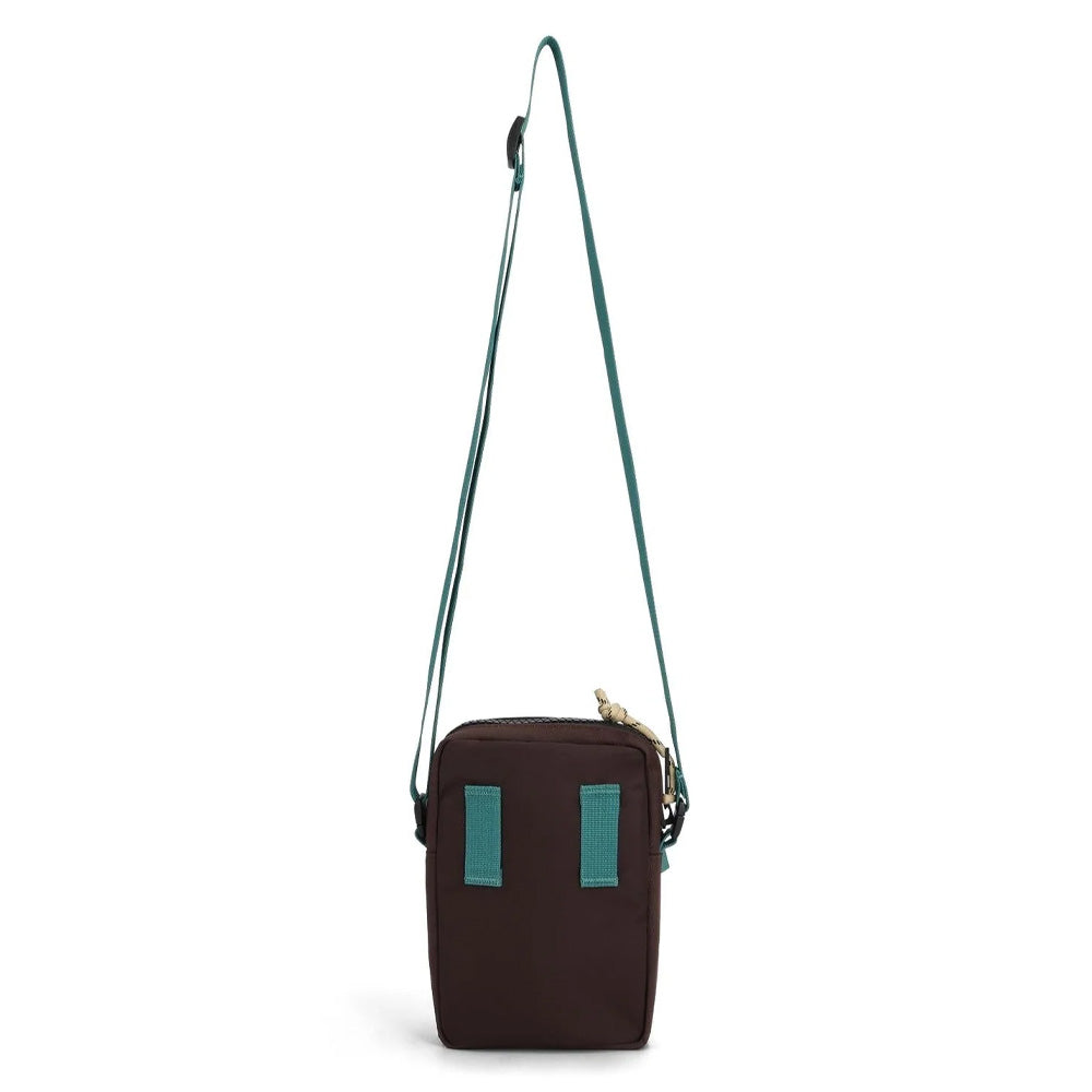 Reverse of small crossbody bag with strap and teal accents on a white background