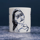 White ceramic mug with dark blue ink design of a different woman.