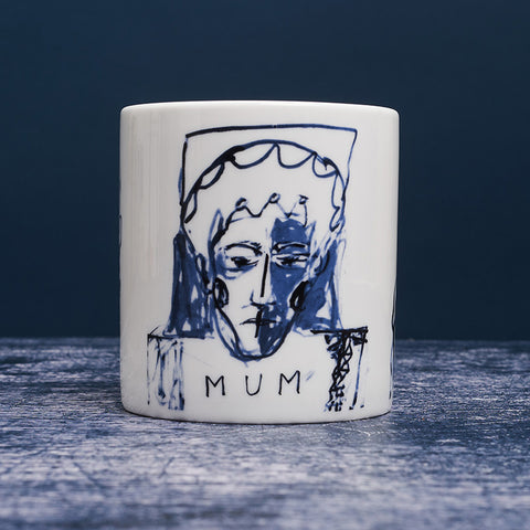 White ceramic mug with dark blue ink design of a woman with "MUM" inscribed below the portrait.