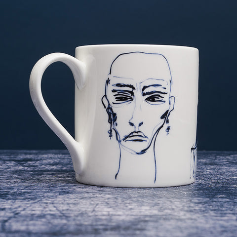 White ceramic mug with dark blue ink design of a woman.