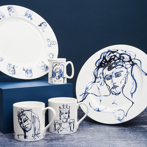 A collection of 2 plates, 2 mugs and a milk jug in white with blue painted portrait designs. 
