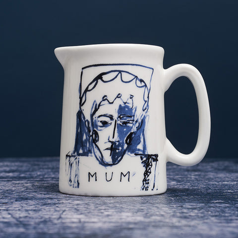 White ceramic milk jug with blue ink portrait painting of a woman with the word 'Mum' below. 