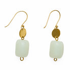 Gold earrings with grey rounded charm on a white background
