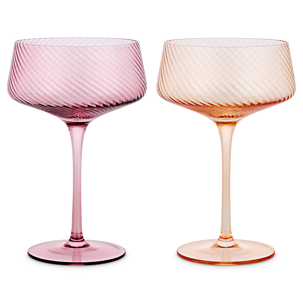Two stemmed cocktail glasses with a textured spiral pattern, one in translucent pink and the other in translucent peach orange, shown side by side on a white background.