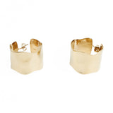 A pair of wide loop earrings made from gold colour textured metal.