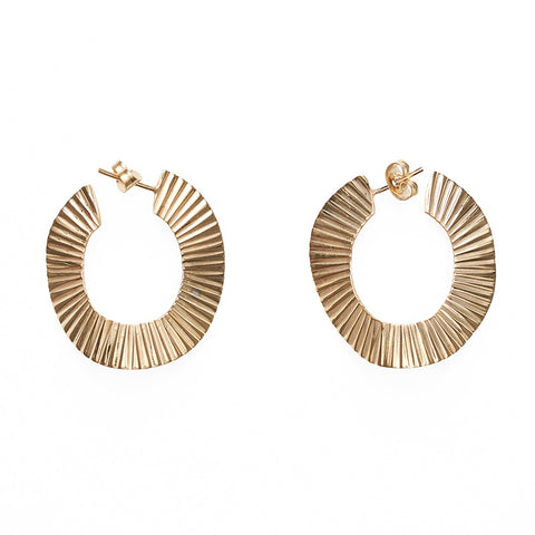 A pair of gold metal round textured earrings.