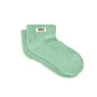 A pair of ribbed socks in light green with a white label and the words Roka London against a white background.