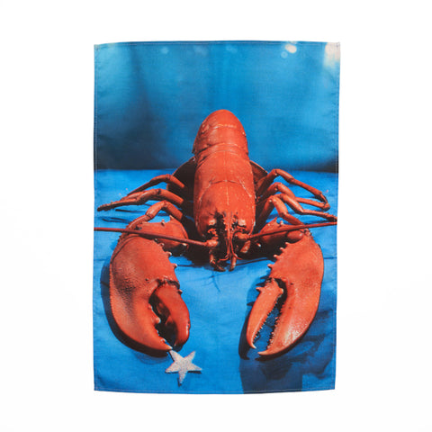 Rectangular tea towel with photographic print featuring a red lobster holding a silver star against blue background, by Yevonde.