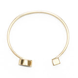Side view of open ended gold bangle.