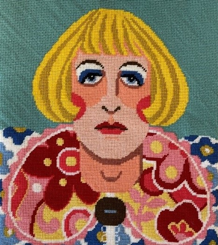 Colourful needlepoint tapestry of Grayson Perry portrait.