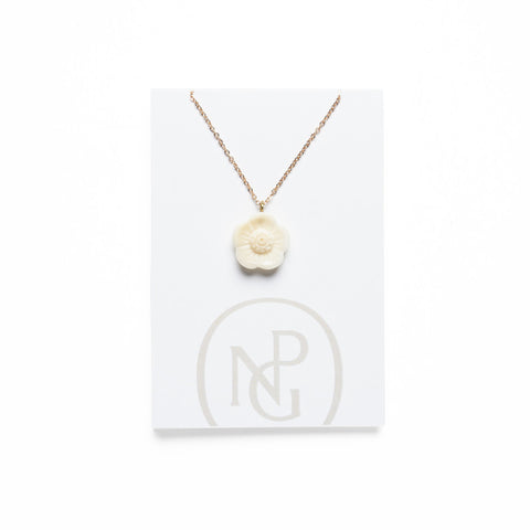 Cream carved flower pendant on gold chain against National Portrait Gallery card packaging.
