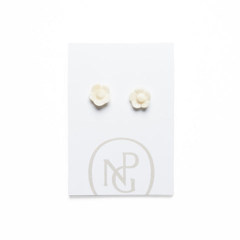 Cream carved flower stud earrings against National Portrait Gallery card packaging.
