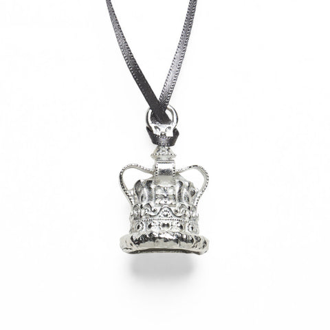 A 3D, silver coloured, pewter crown hanging from a black ribbon.